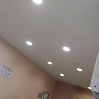 Ceiling with several recessed lights over a room with peach-colored walls.