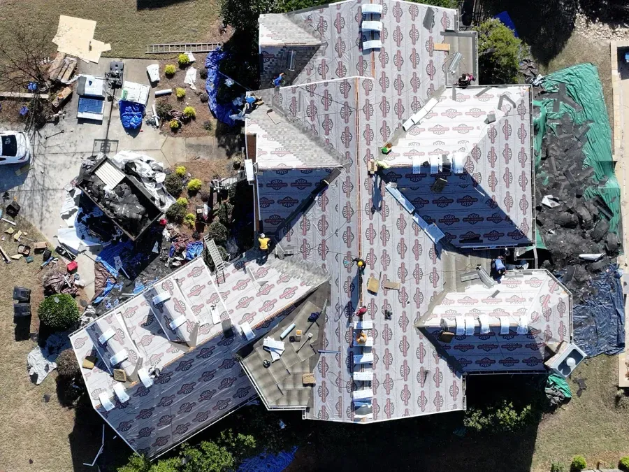 Aerial view of a damaged roof and debris around a collapsed building site.