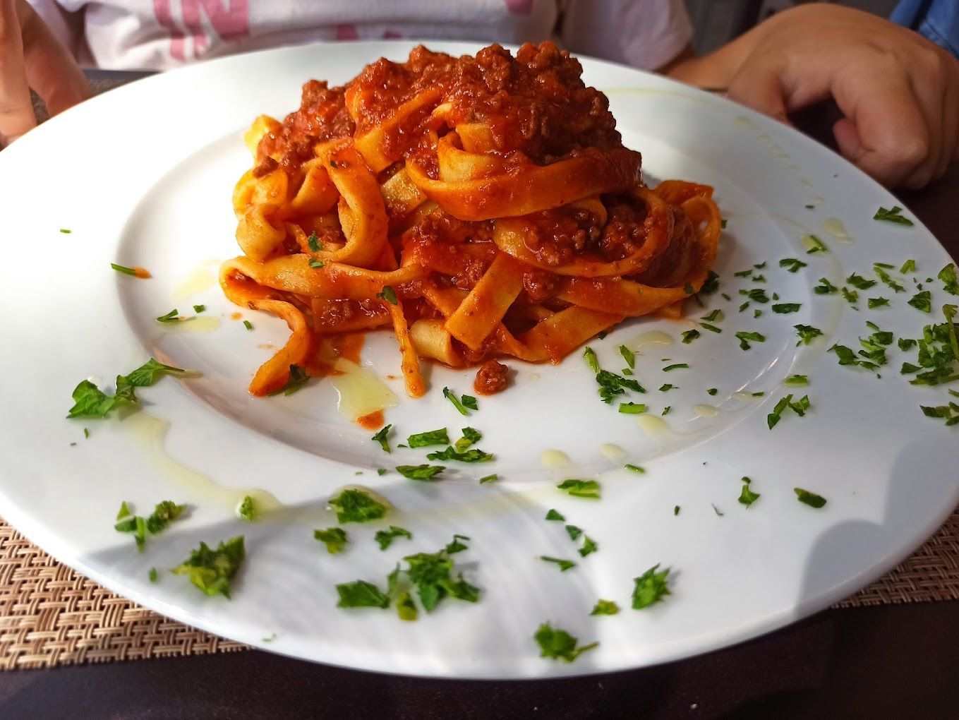 Un piatto bianco con sopra tagliatelle e salsa