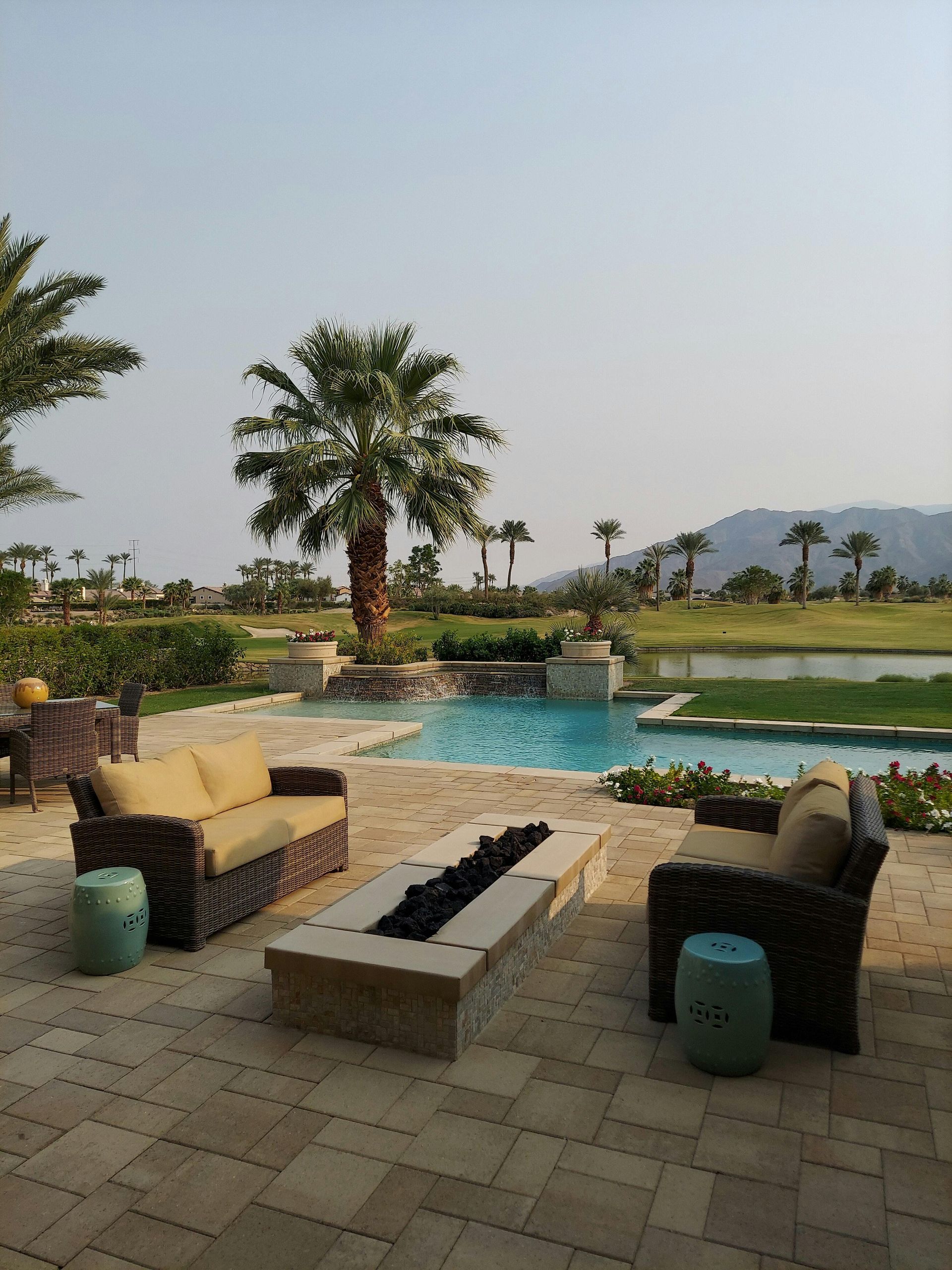 Landscape design with hardscape, mini pool, coconut tree, smooth green sod, and neatly trimmed plant