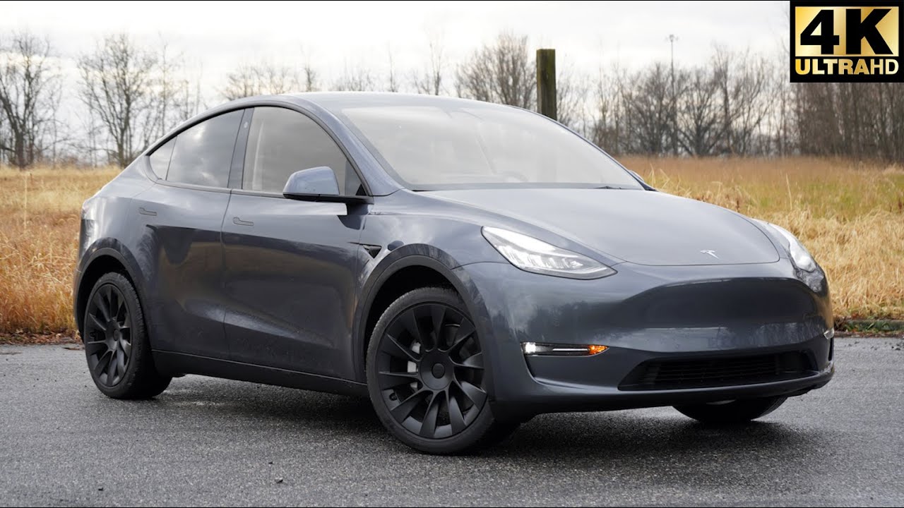 A tesla model y is parked on the side of the road.