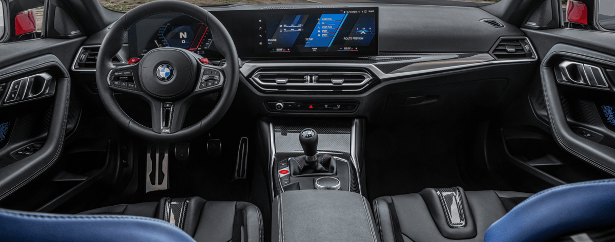 The interior of a bmw m4 is shown with blue seats and a steering wheel.