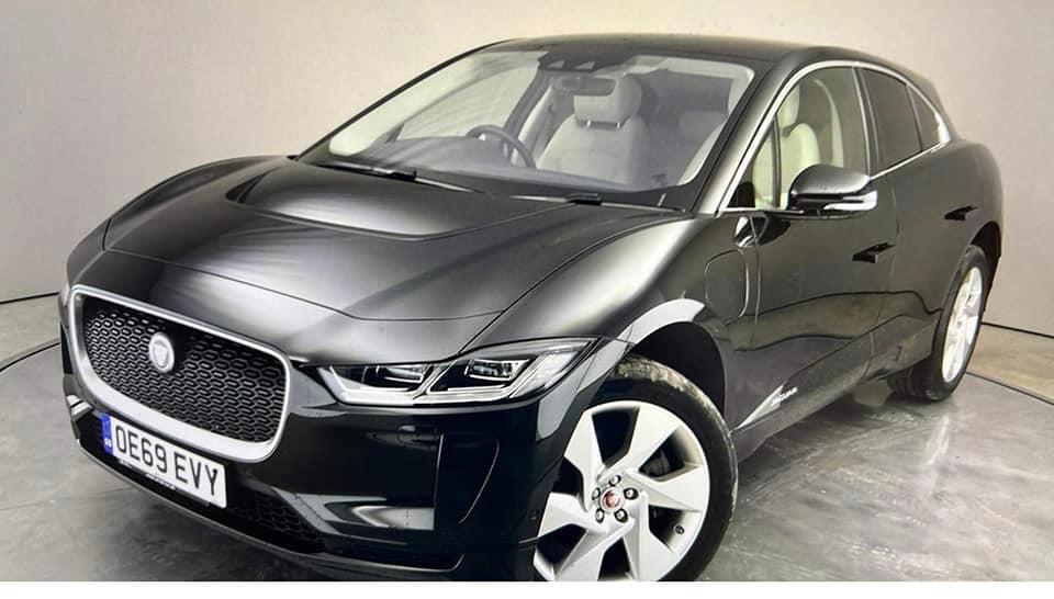 A black jaguar i pace is parked in a showroom.