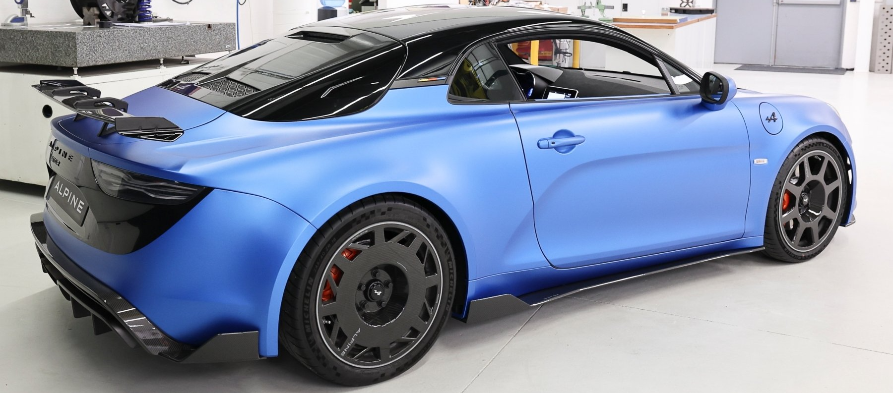 A blue sports car is parked in a garage.