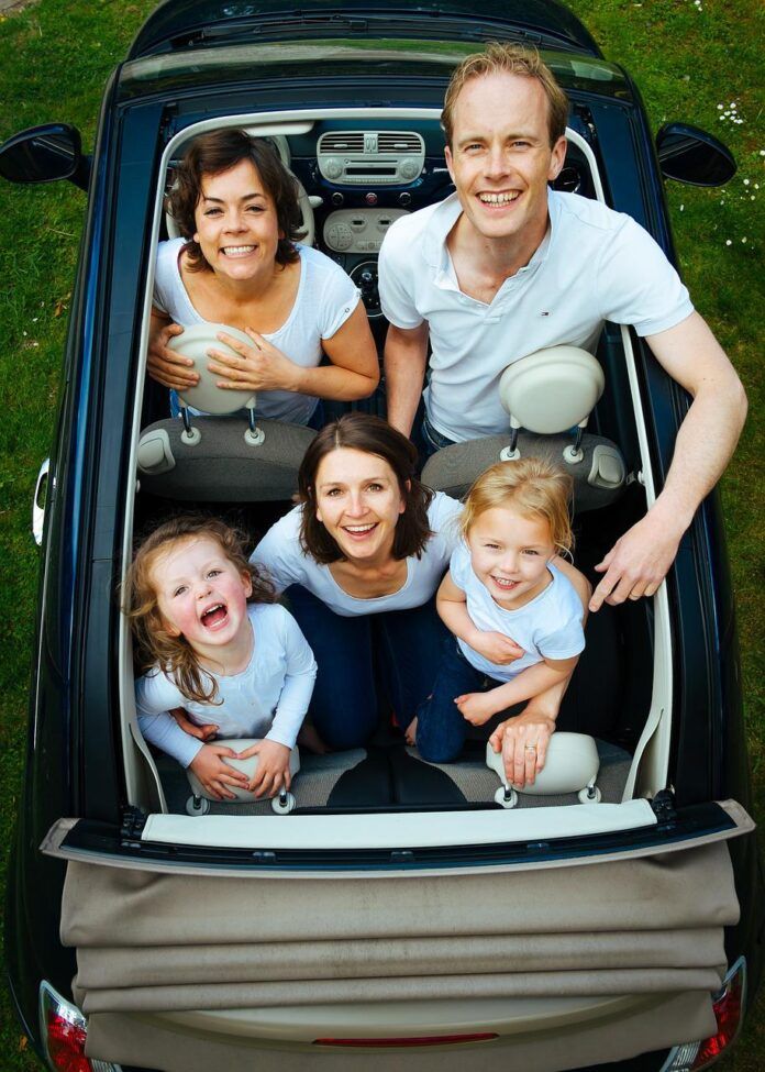 A family is sitting in the back of a car.