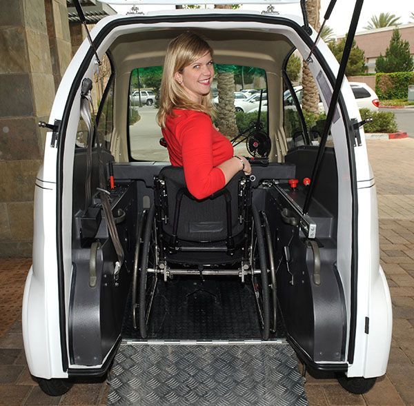 A woman in a wheelchair is sitting in the back of a car