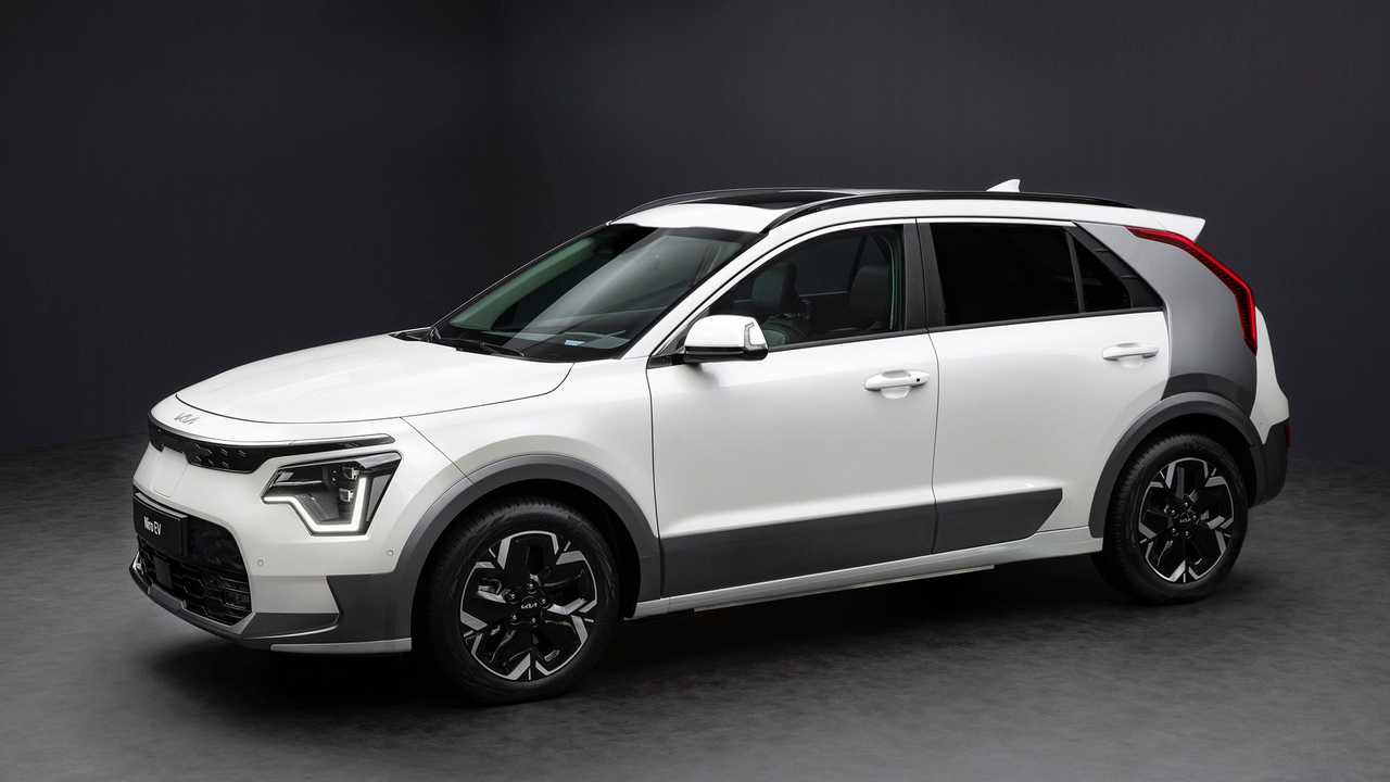 A white car is parked in a dark room.