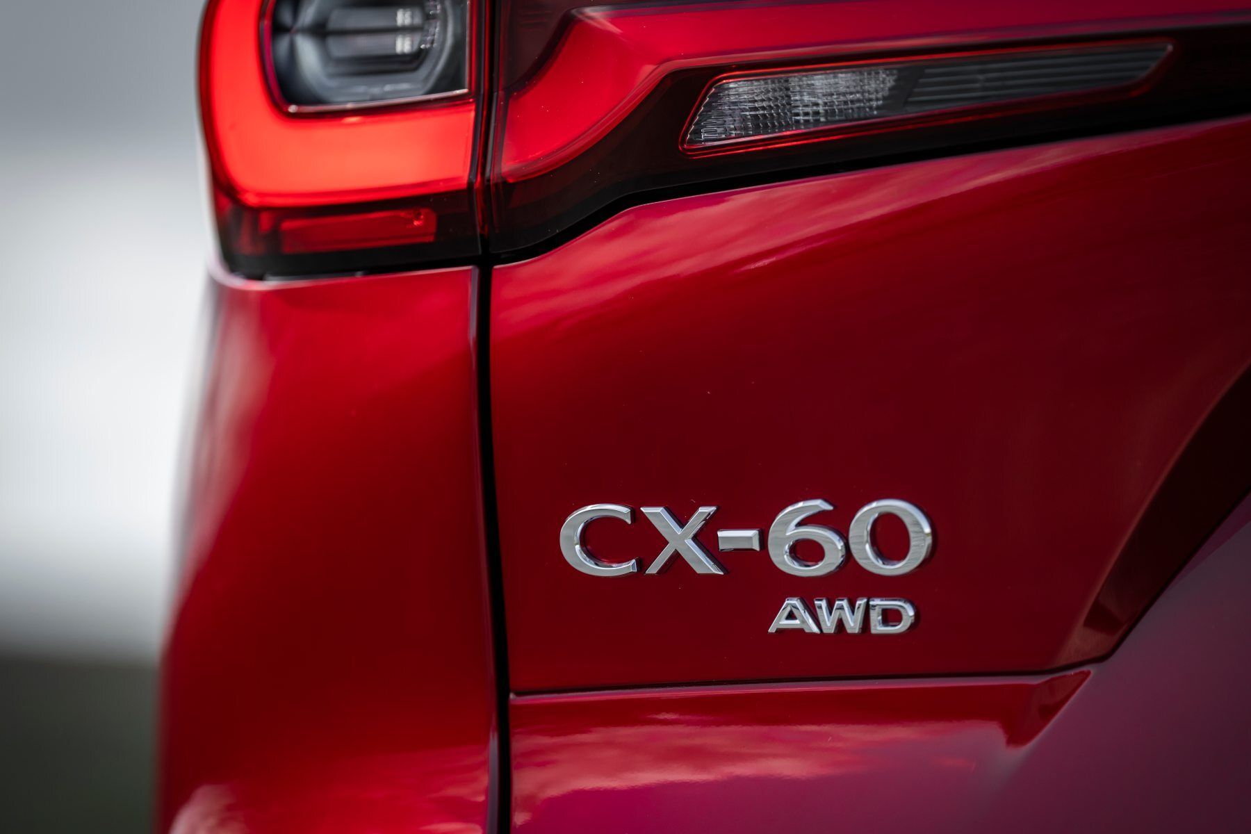 A close up of the rear end of a red mazda cx-60 awd.