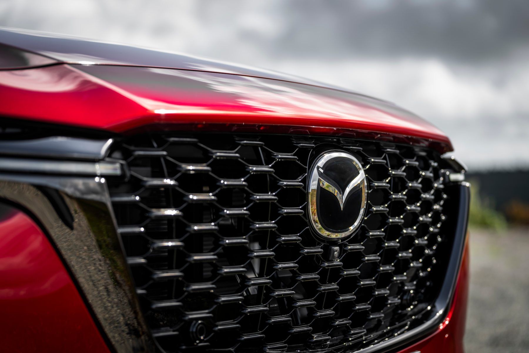 A close up of the front grille of a red mazda cx 5.