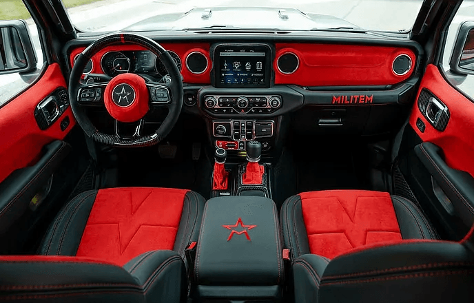 The interior of a jeep wrangler with red and black seats.