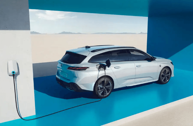 A white electric car is being charged at a charging station.