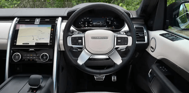 The interior of a land rover discovery with a steering wheel and dashboard.
