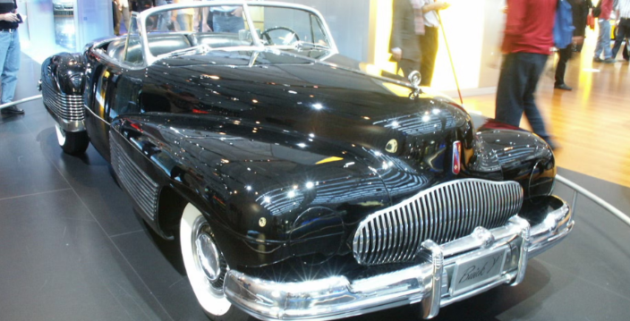 A black buick convertible is on display at a car show.