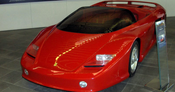 A red sports car is on display in a museum