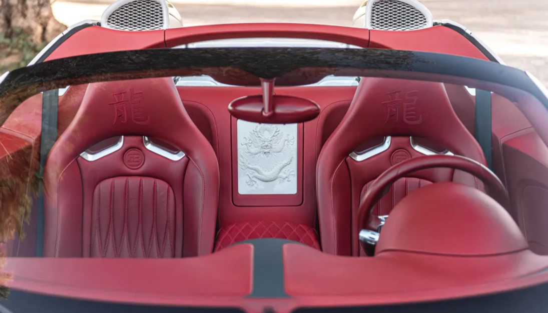 The inside of a red sports car with red seats and a steering wheel.