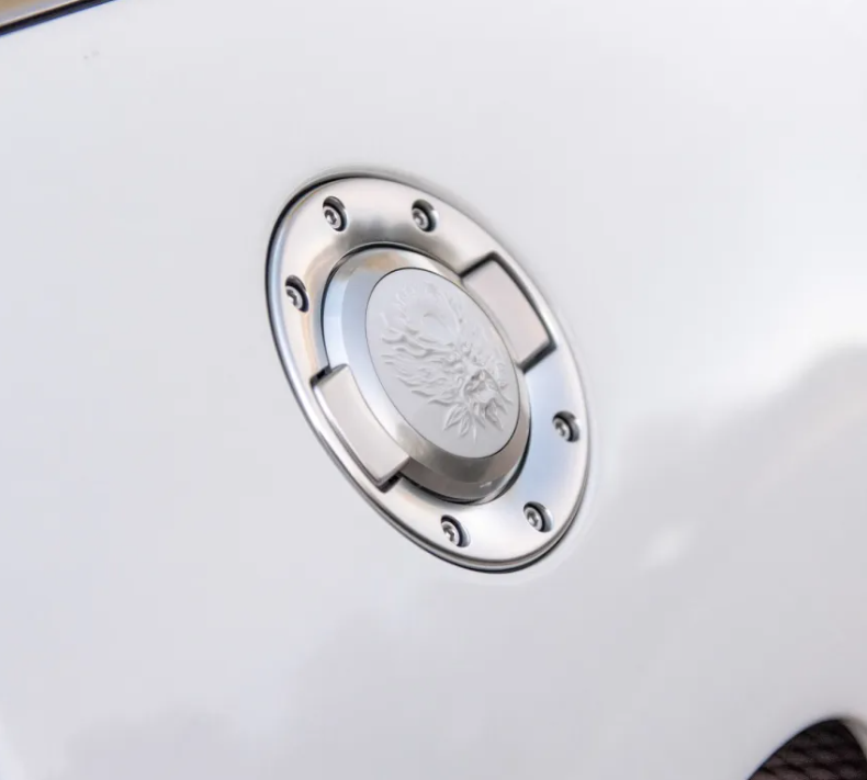 A close up of a fuel cap on a white car
