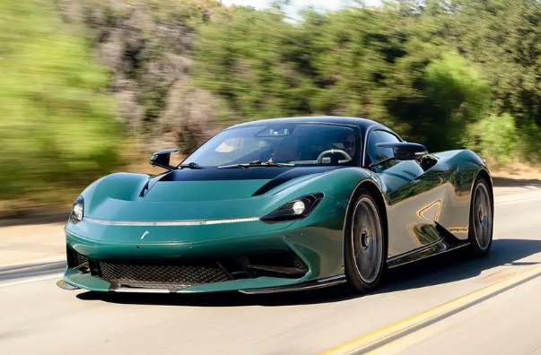 A green sports car is driving down a road.