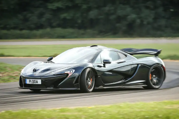 A black mclaren p1 is driving down a race track.