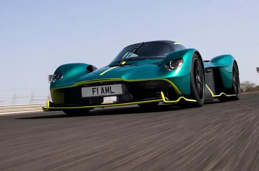 A green and yellow sports car is driving down a road.