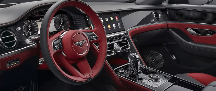The interior of a bentley continental gt convertible with a red steering wheel.