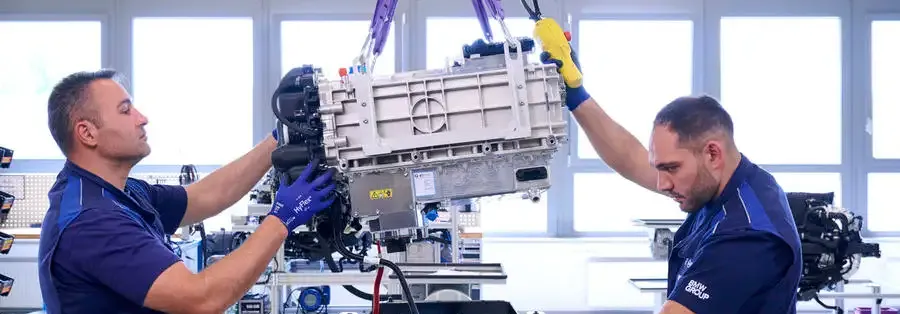 Two men are working on a machine in a factory.