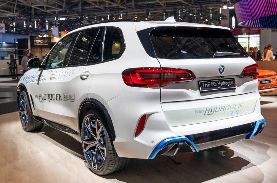 A white bmw x5 is on display at a car show.