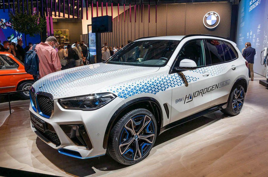 A white bmw x5 is on display at a car show.
