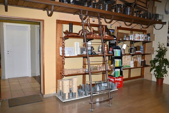 Una stanza con scaffali e una scala al suo interno
