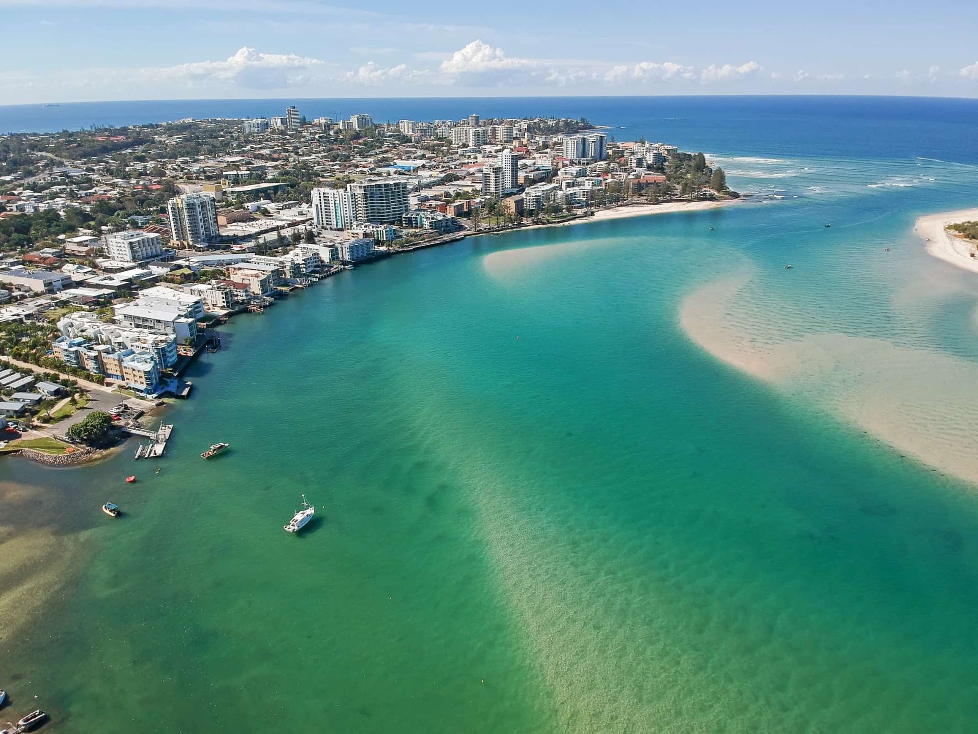 Coastal city with buildings along a turquoise waterway flowing into the ocean. — Metal Fabrication on the Sunshine Coast QLD