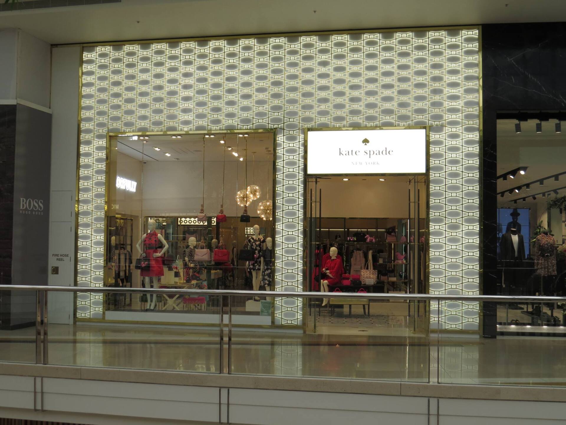 Kate Spade store front with patterned facade and display windows.