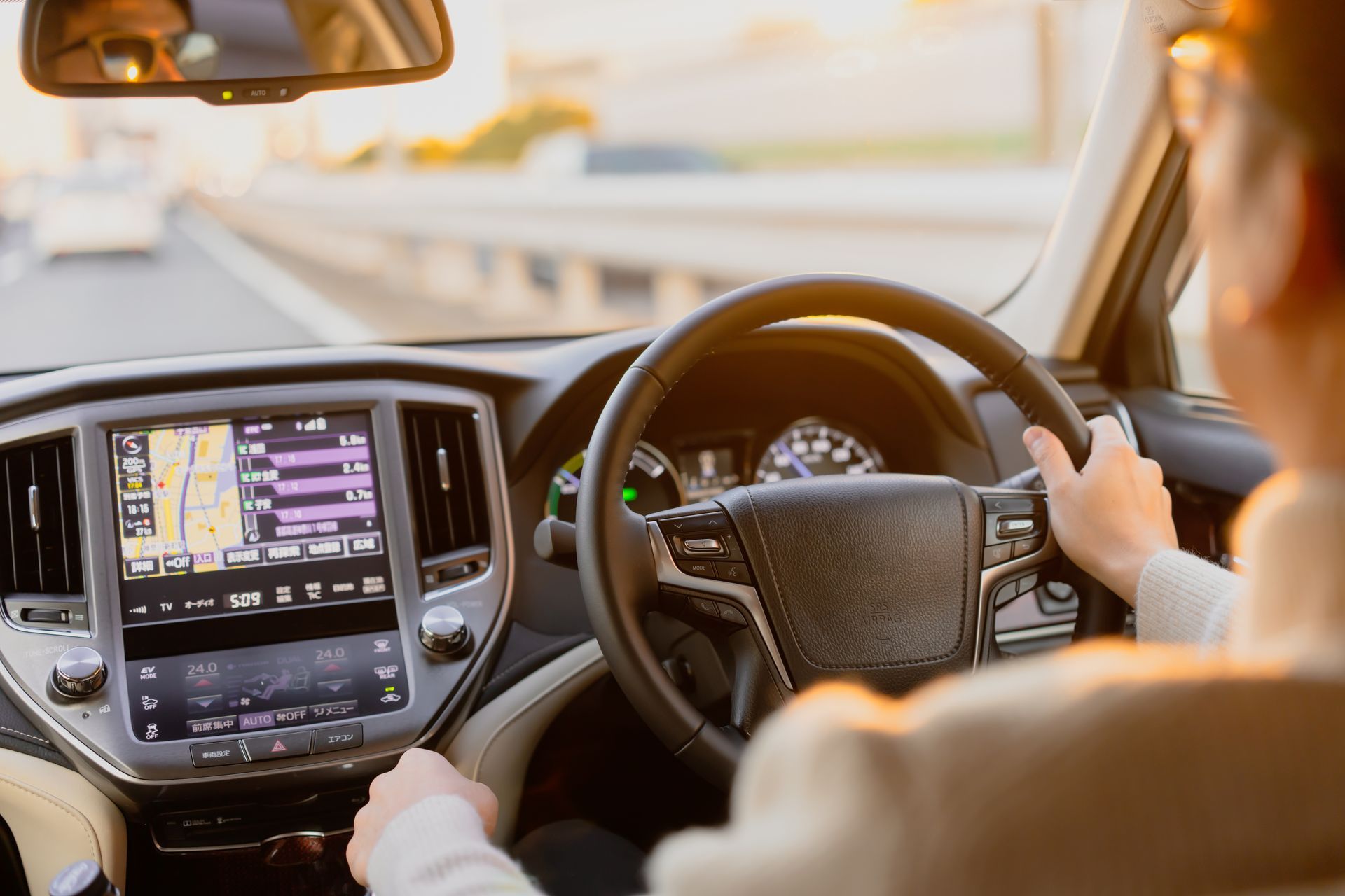 a person driving a car with a focus on the steering wheel and dashboard. a person driving a car with a focus on the steering wheel and dashboard.