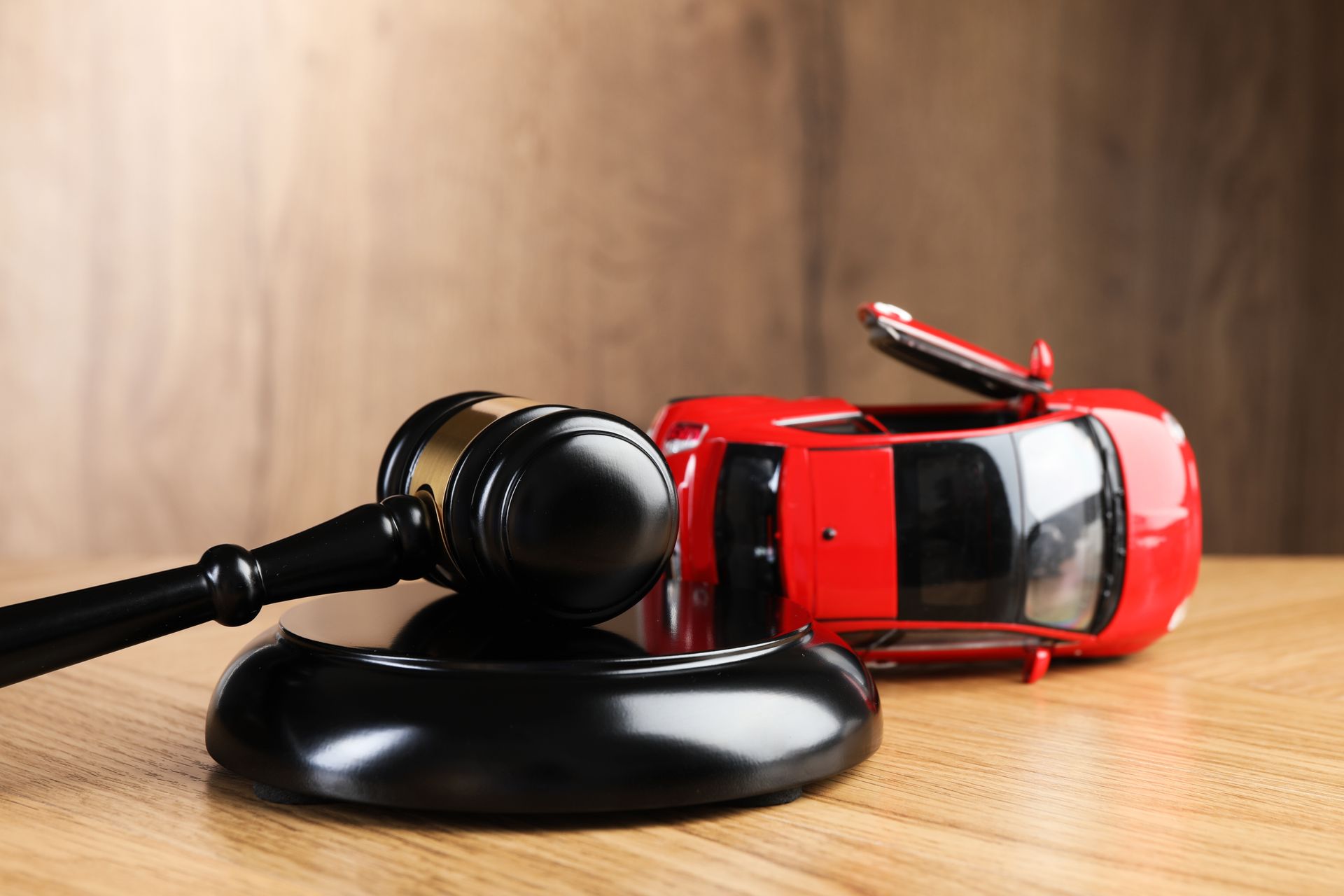 Motor vehicle accident law. Gavel and car model on wooden background Motor vehicle accident law. Gavel and car model on wooden background