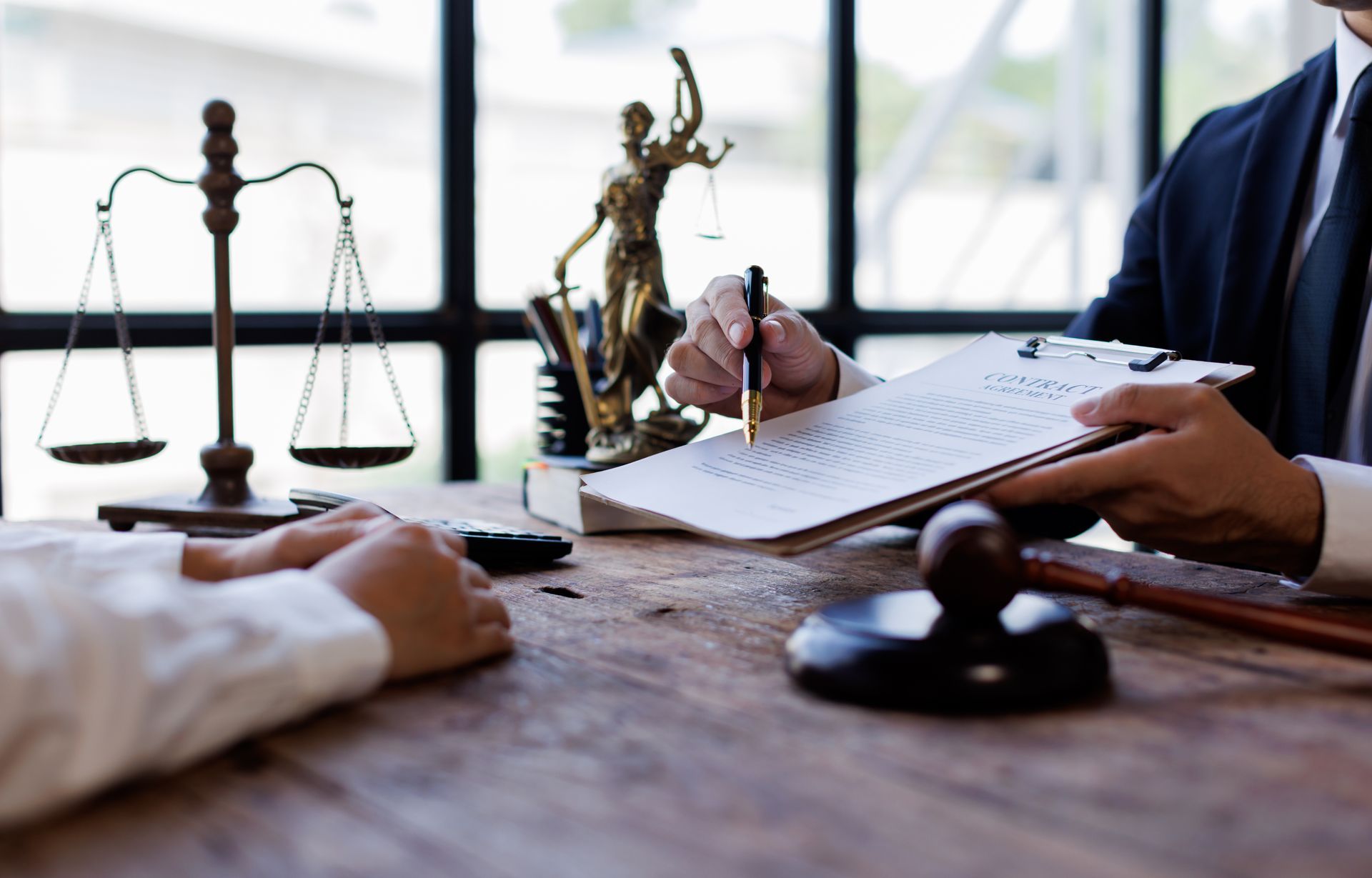 A consultation between a personal injury attorney and a client at a desk with a wooden gavel. A consultation between a personal injury attorney and a client at a desk with a wooden gavel.