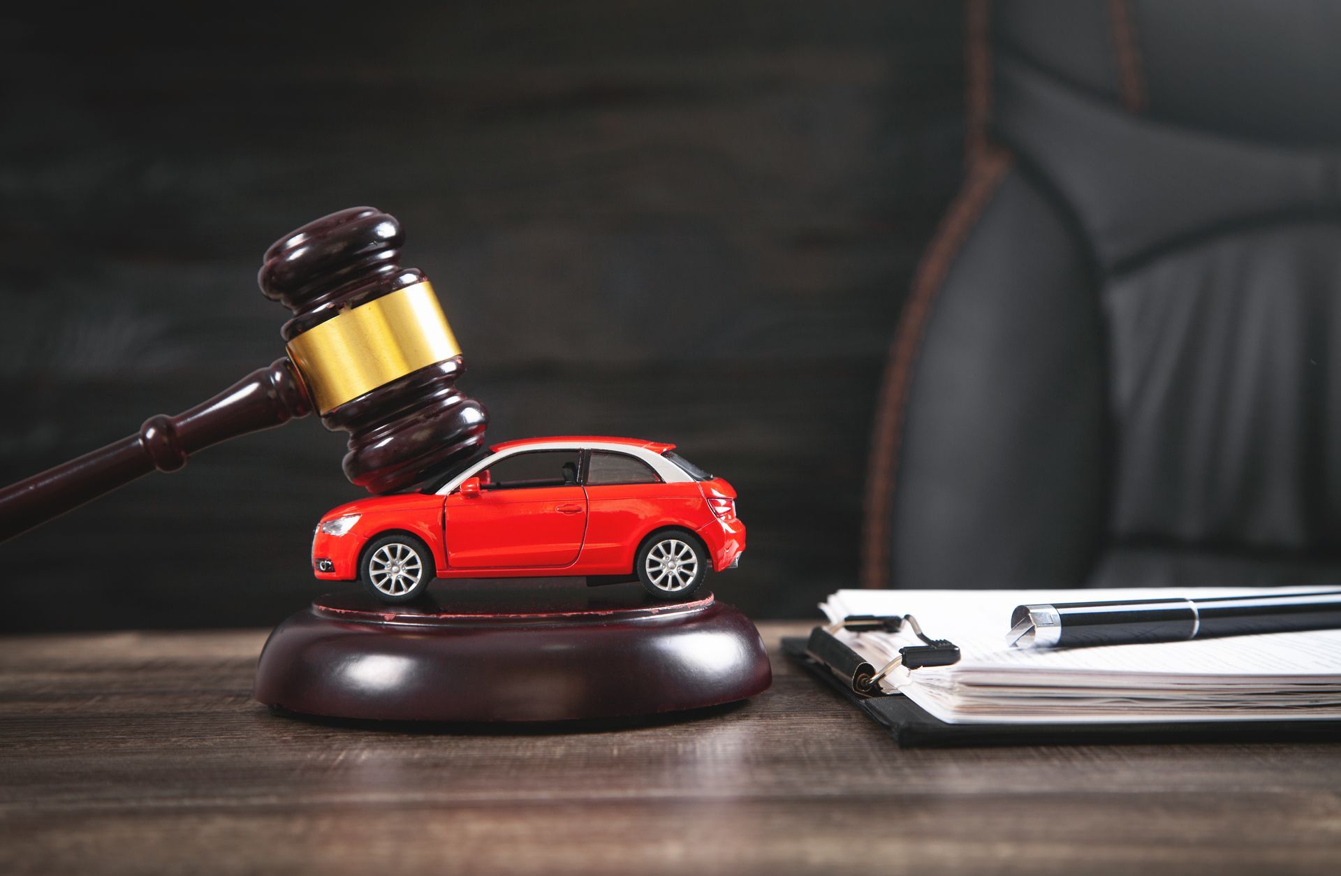 Auto accident attorney gavel with red car model on desk. Auto accident attorney gavel with red car model on desk.