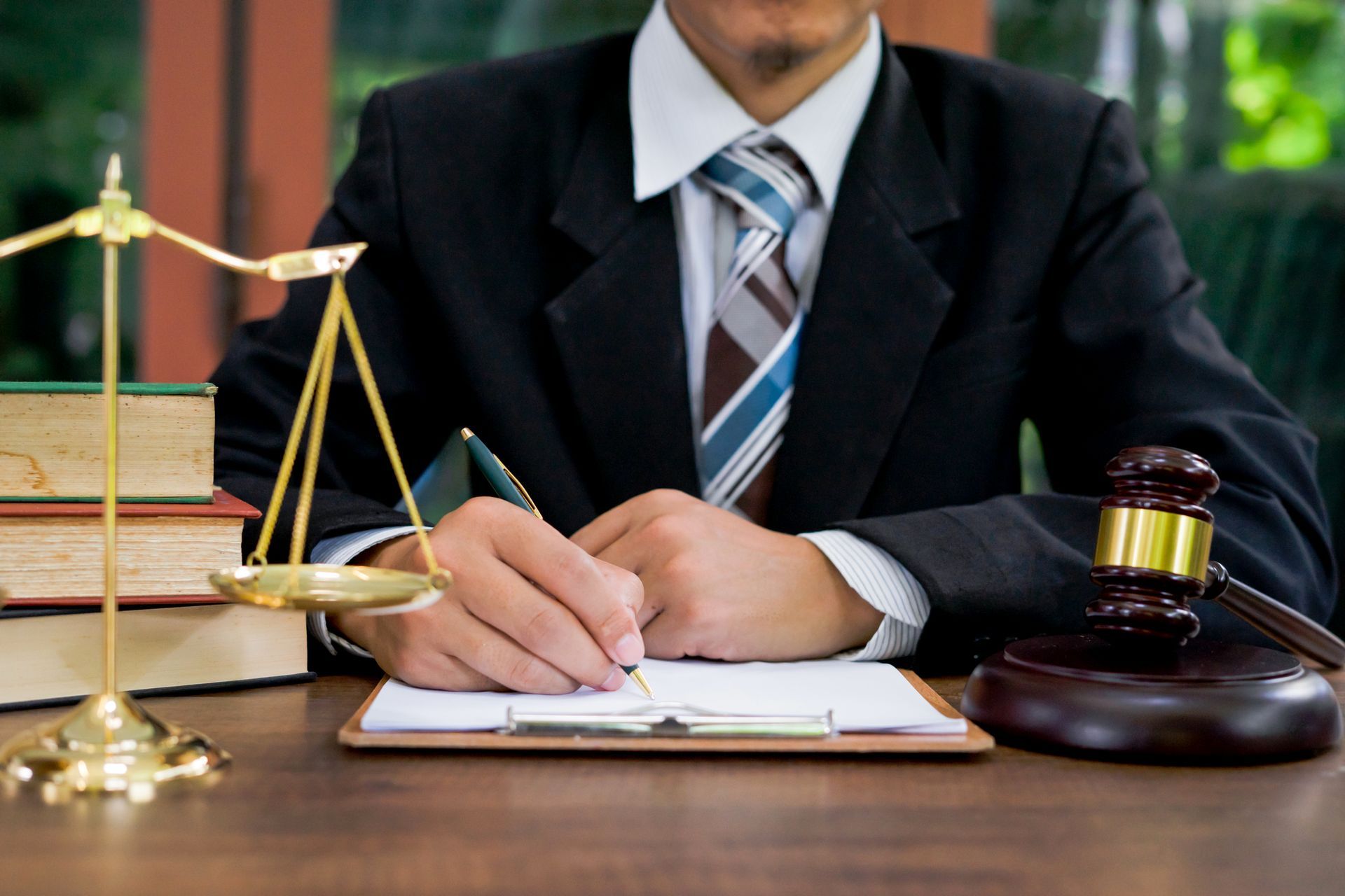 Lawyer at wooden desk with gavel and sound block symbolizing justice. Lawyer at wooden desk with gavel and sound block symbolizing justice.