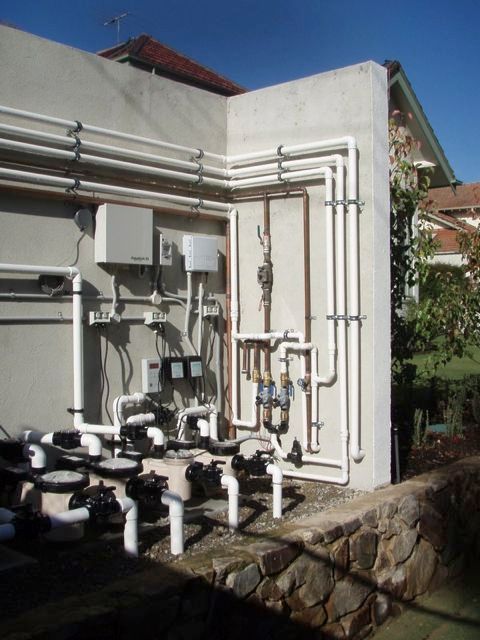 A wall with a bunch of pipes attached to it