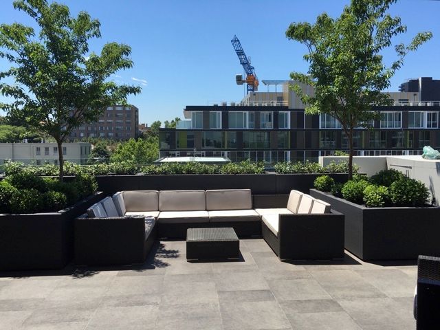 A patio with a sectional couch and a table