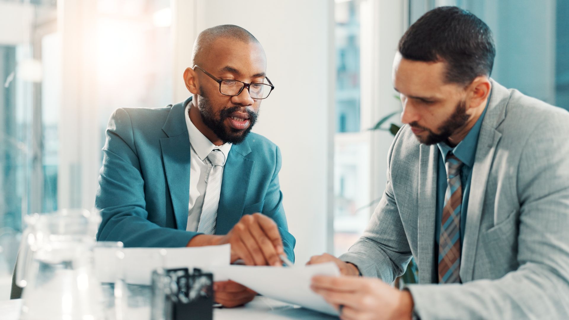 Two men in suits reviewing documents
