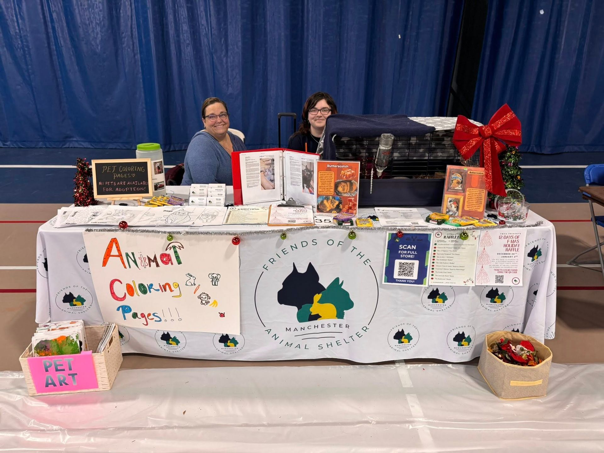 Two people staff an indoor booth for