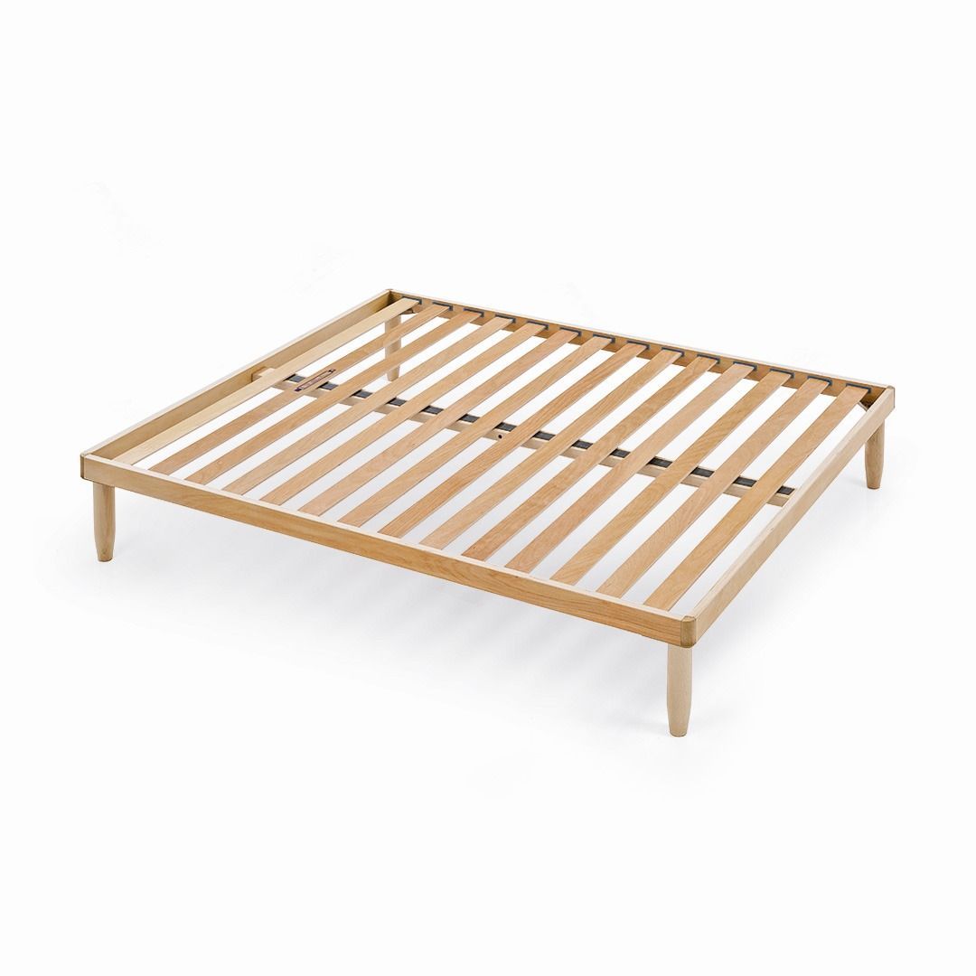 Una struttura letto a doghe in legno chiaro con quattro gambe abbinate, mostrata su uno sfondo bianco uniforme.