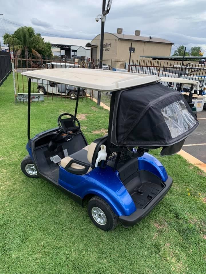 A Blue Golf Cart Is Parked in A Grassy Field — DTM Tamworth in Tamworth, NSW