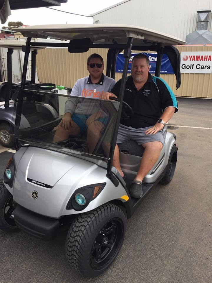 Two Men Are Sitting in A Silver Golf Cart — DTM Tamworth in Narrabri, NSW