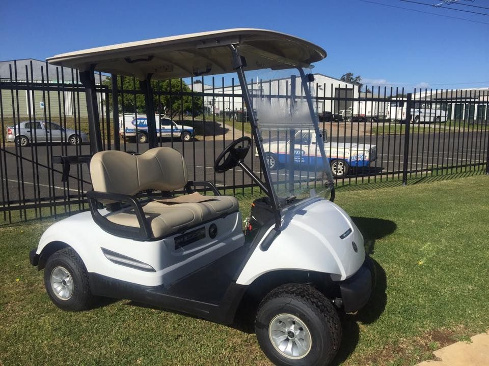 A White Golf Cart Is Parked in The Grass — DTM Tamworth in Tamworth, NSW