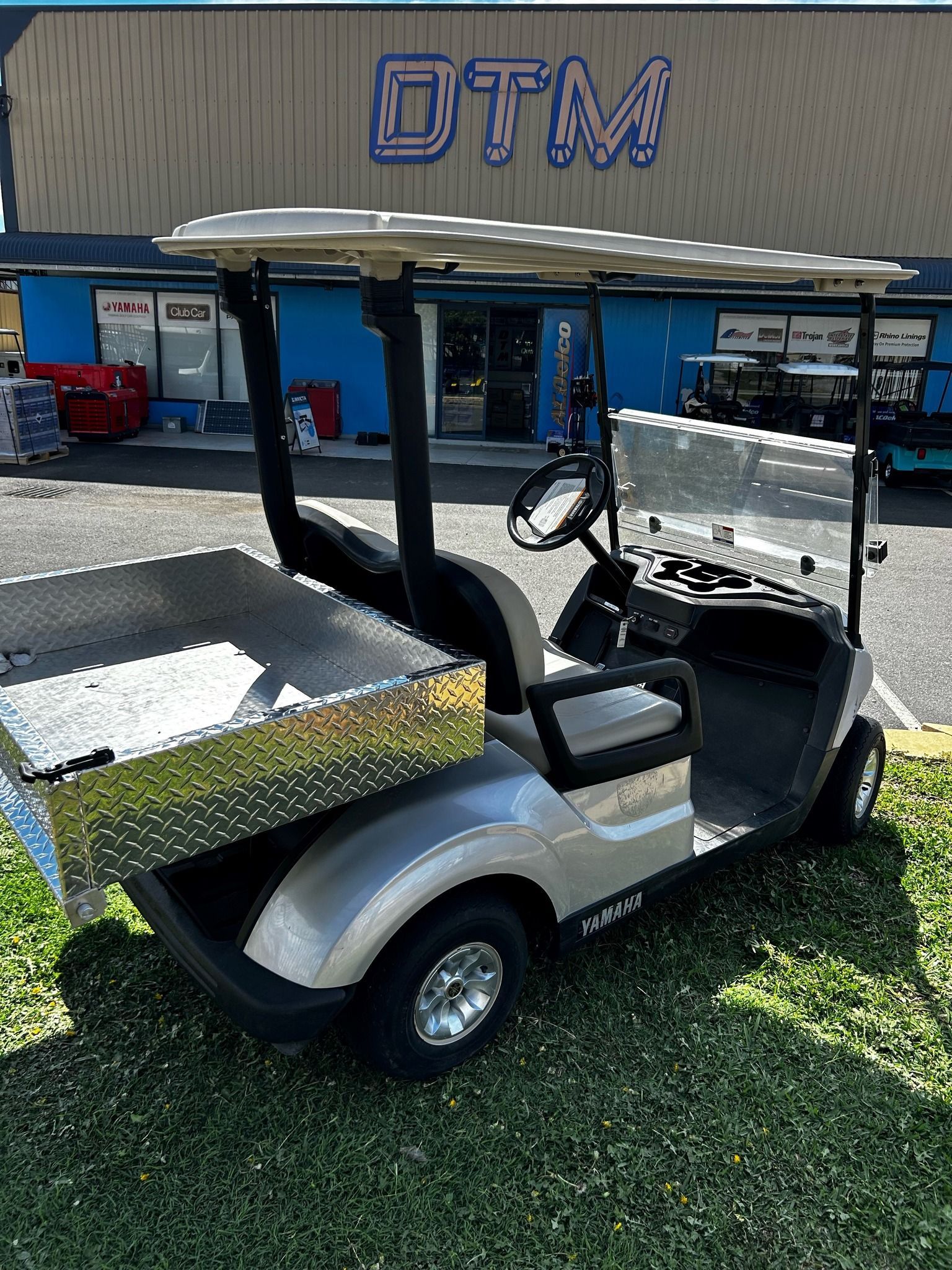 A Silver Golf Cart Is Parked on The Grass Outside Shop — DTM Tamworth in Tamworth, NSW
