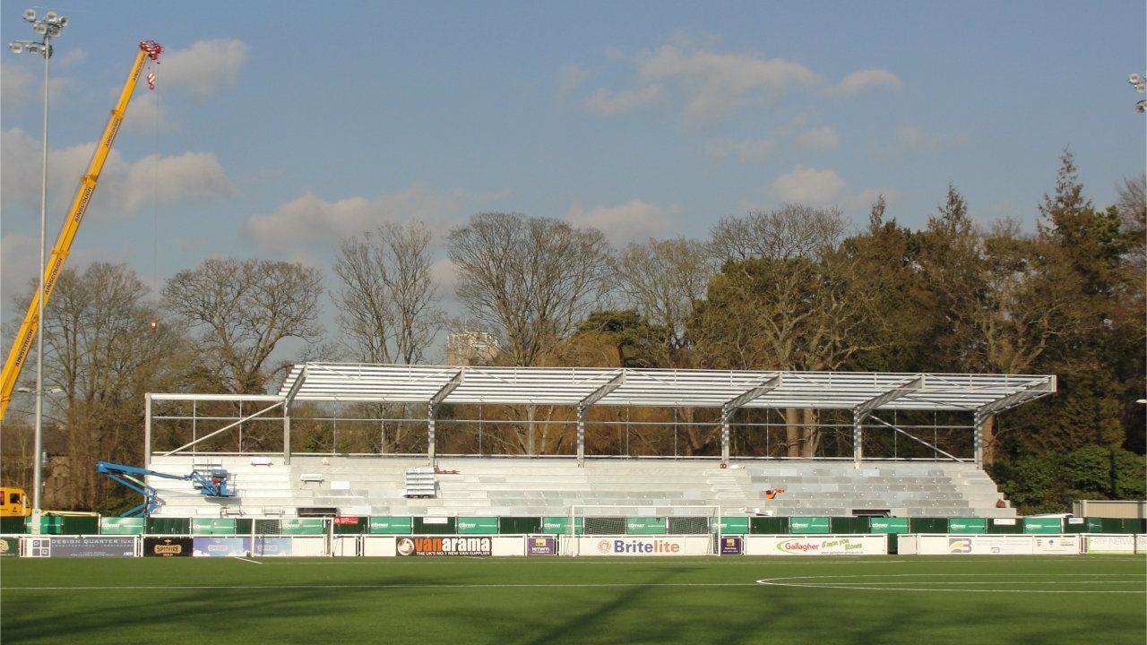 A soccer field with a crane in the background.