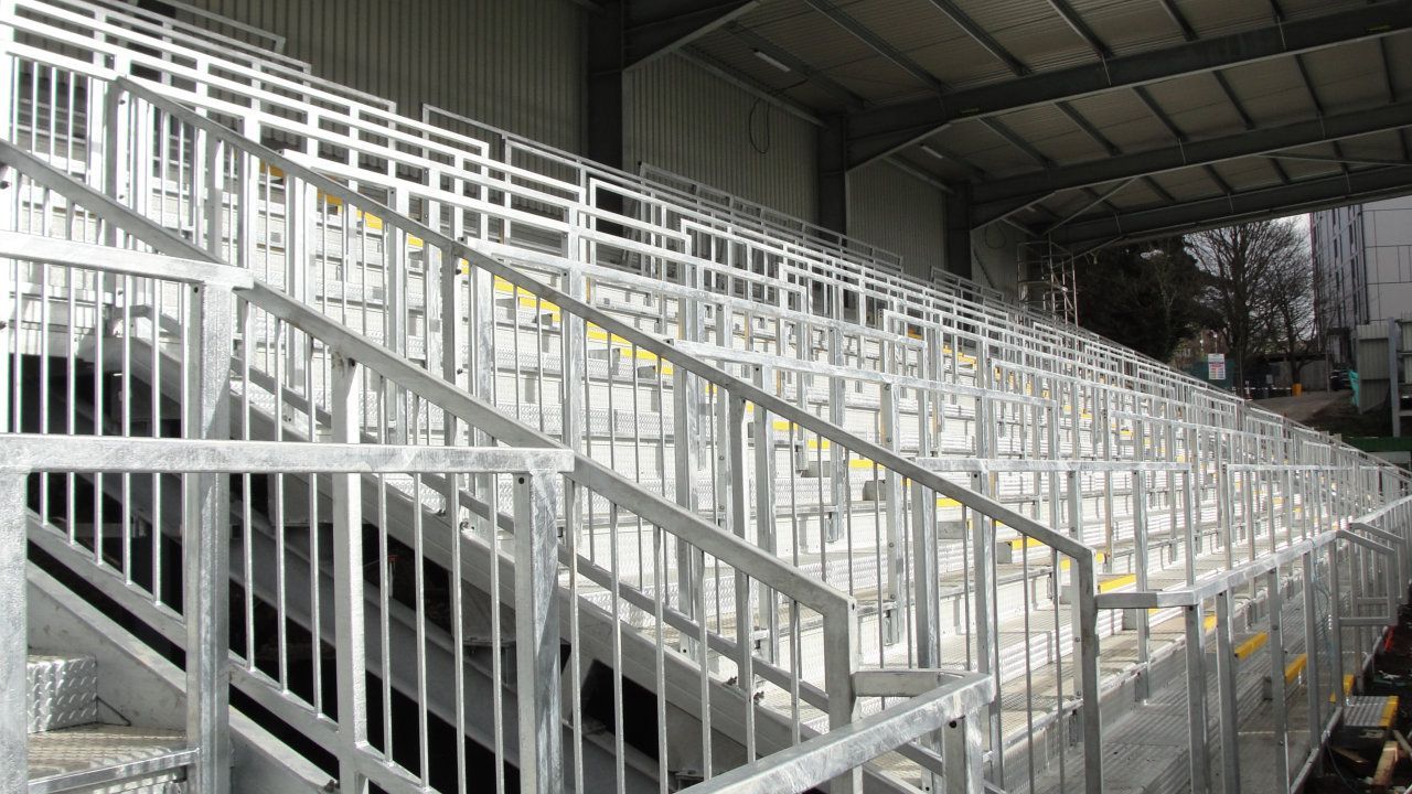 A row of metal stairs leading up to a stadium.