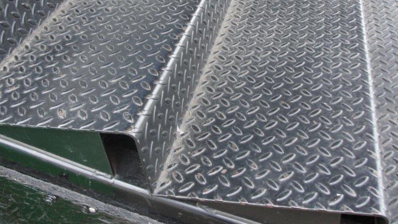 A close up of a metal staircase with a diamond pattern.