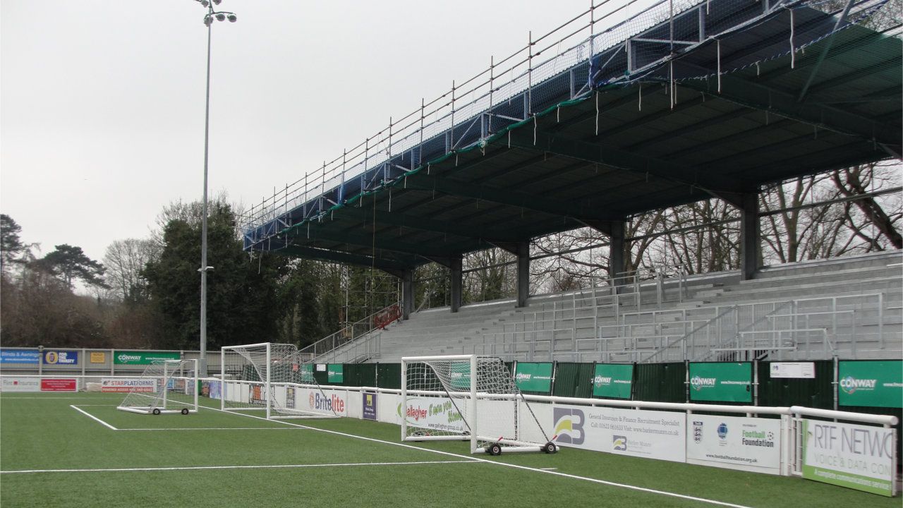 A soccer field with a bridge in the background