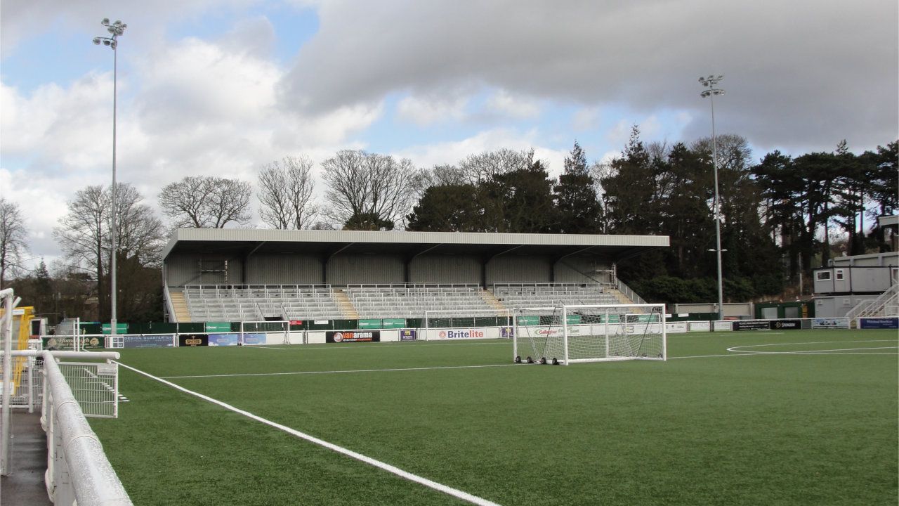 A soccer field with a stadium in the background