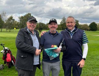 Three men are posing for a picture on a golf course.